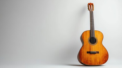 Fototapeta premium A solitary acoustic guitar, its wooden body gleaming under the soft, diffused light of a white background, stands as a symbol of tranquility and musical expression.