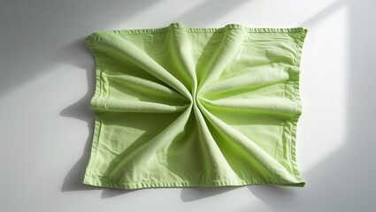 Simple green fabric displayed with folds on a flat surface in natural light creates an elegant visual effect during the daytime