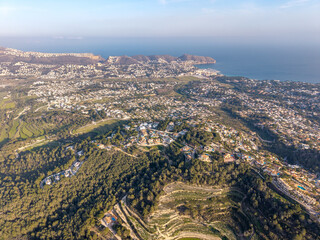 Aerial view of terraced green fields and rural roads in Spain.