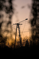 Słup energetyczny do przesyłania prądu z lampą oświetlającą ulice © Stefan