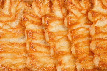 Close-up shot of several Palmier cookies, showcasing their flaky layers and caramelized surfaces.