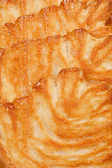 Close-up shot of several Palmier cookies, showcasing their flaky layers and caramelized surfaces.