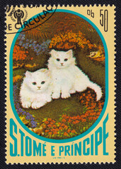 Two cute white kittens is depicted on an old vintage cancelled postage stamp printed in Sao Tome...