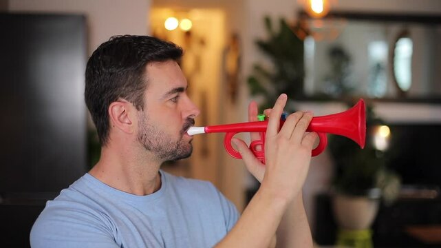 Funny man playing the trumpet at home during the night 