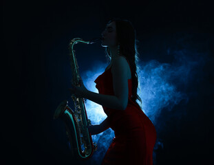 Professional musician playing saxophone on dark background with blue light and smoke