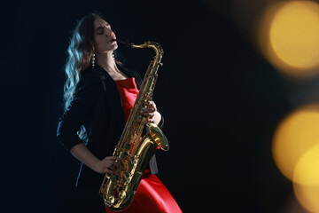 Obraz premium Professional musician playing saxophone on black background with blurred lights. Bokeh effect