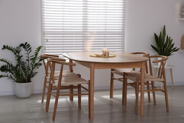 Stylish wooden table with chairs and decor indoors. Interior design