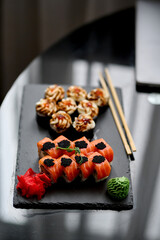 Sushi set on a black background. Sushi roll with salmon, caviar, cream cheese and wasabi.