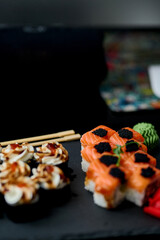 Sushi set on a black background. Sushi roll with salmon, caviar, cream cheese and wasabi.