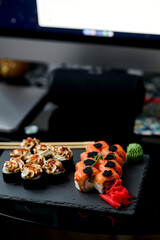 Sushi set on a black background. Sushi roll with salmon, caviar, cream cheese and wasabi.