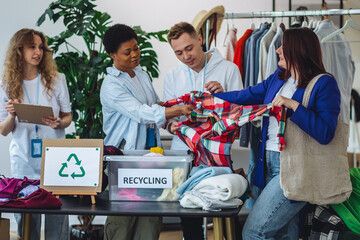 Young woman brings old clothes for recycling, charity, donation. Eco conscious responsible lifestyle. Volunteers sorting textile to prevent pollution, environment protection. Second hand shopping