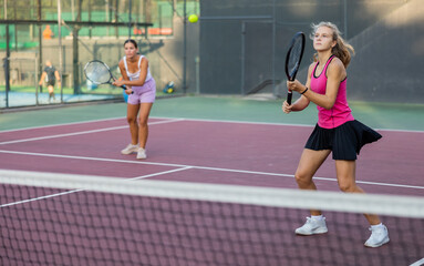 Obraz premium Portrait of emotional woman tennis player during friendly doubles couple match at court