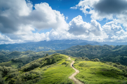 Backpacker walking on a trail in the rolling green hills under a cloudy sky