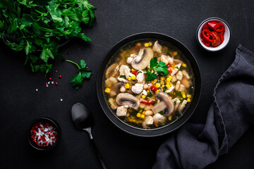 Spicy soup with chicken, mushrooms, corn, white beans, chili and cilantro. White background, top view
