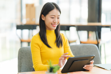 Smiling Asian Woman Using Tablet