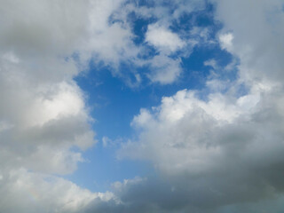 Fototapeta premium The sky is cloudy and the sun is not visible. The clouds are white and grey. The sky is blue and the clouds are scattered