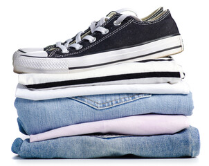 Stack of clothes and black sneakers on a white background. Isolation