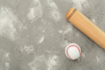 Wooden baseball bat on concrete background, top view