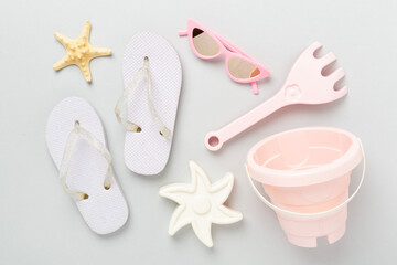 Children's flip-flops and beach toys on color background,,top view