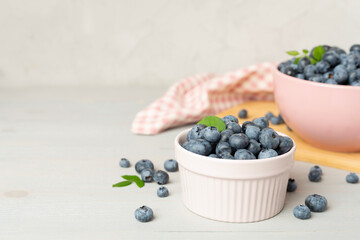 Bowl with fresh bright blueberries on wooden table