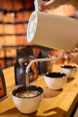 Pouring a Hot Beverage into Beautifully Crafted Stylish Cups for Everyone to Enjoy Together