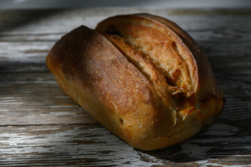 Freshly baked artisan bread on rustic wooden table with soft lighting in cozy kitchen setting