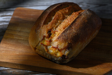 Freshly baked artisan bread on a rustic wooden cutting board in warm afternoon light