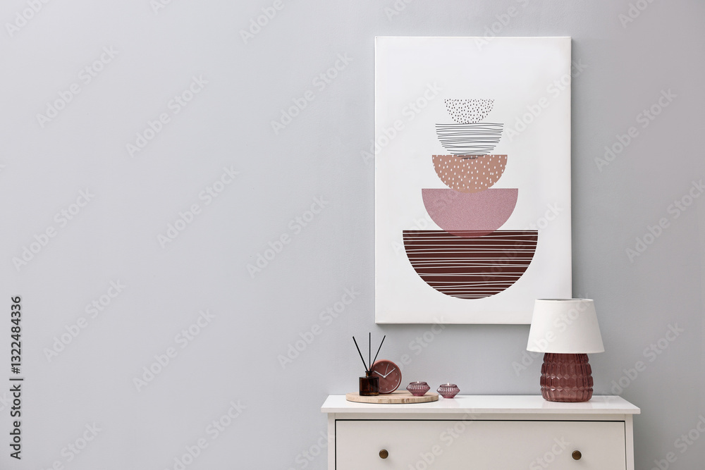 Poster console table with lamp, clock reed diffuser and candles near light grey wall, space for text. inter