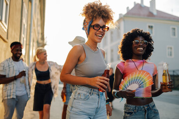 Two female friends walking and smiling at pride parade