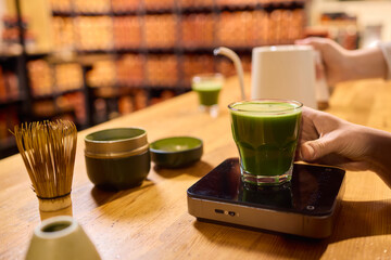 Pouring exquisite Matcha Tea into a stylish Glass while enjoying the serene atmosphere