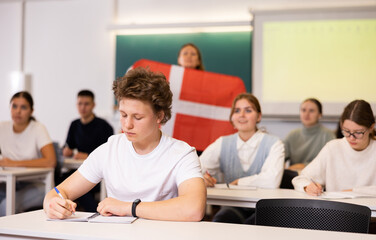 Fototapeta na wymiar Young student attentively listening to a lecture in a classroom