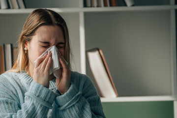 young woman 20s with handkerchief and flu or cold symptoms