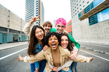 Happy multiracial friends having fun on city street - Group of young people smiling at camera outside - Friendship concept with guys and girls walking in downtown road