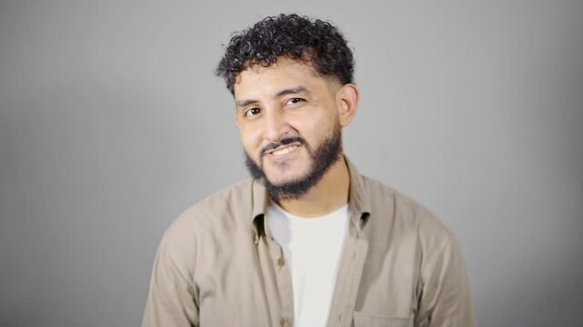 Young hispanic man making different facial expressions on gray background