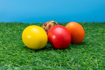 Colorful Painted Easter Eggs on Green Artificial Grass with Blue Background