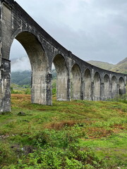Close-up view of the Glenfinnan Viaduct from below, set against a cloudy sky on a spring day. Scotland, UK.