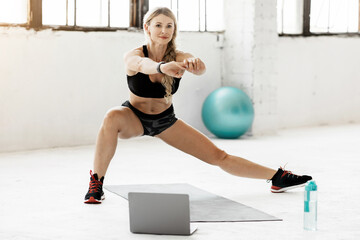 Online exercise at home during covid-19 pandemic and self-isolation. Calm adult lady in sportswear...