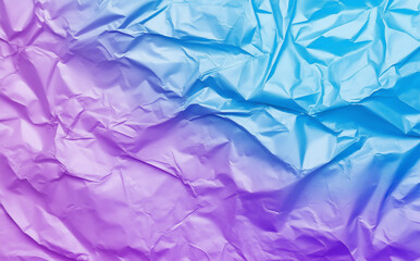 Obraz premium A close-up of crumpled purple and blue paper forms an abstract background with a textured surface, emphasizing the folds and creases for a visually intriguing and dynamic composition