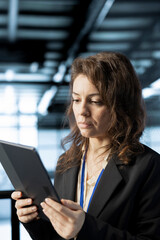 Woman in data center operating tablet, analyzing metrics, optimizing storage volumes, reviewing...