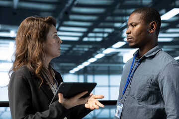 IT staff members in data center using tablet to develop disaster recovery plans. Coworkers in server hub doing brainstorming, testing failover scenarios, protecting data during disruptions