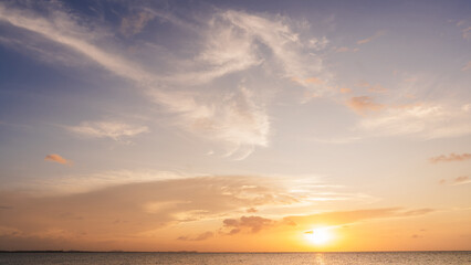 Sunset sky Clouds over sea in the Evening with Orange, Yellow sunlight on golden hour, Horizon sea sky landscape nature background, Summer sea Sky