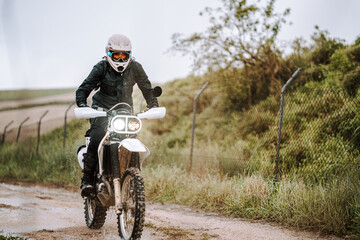 Motorista creando contenido en dia lluvioso en camino de barro inundado