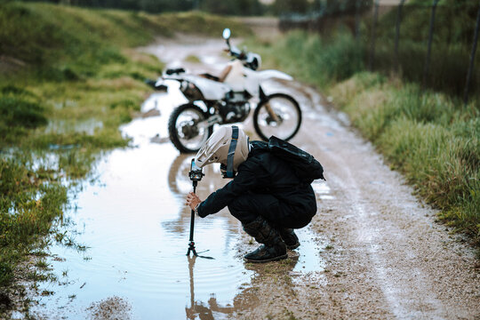 Motorista creando contenido en dia lluvioso en camino de barro inundado