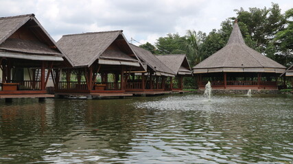 Obraz premium Saung (gazebo) or resting place made of bamboo above a fish pond.