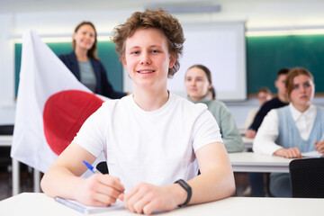 Obraz premium Young student attentively listening to a lecture in a classroom