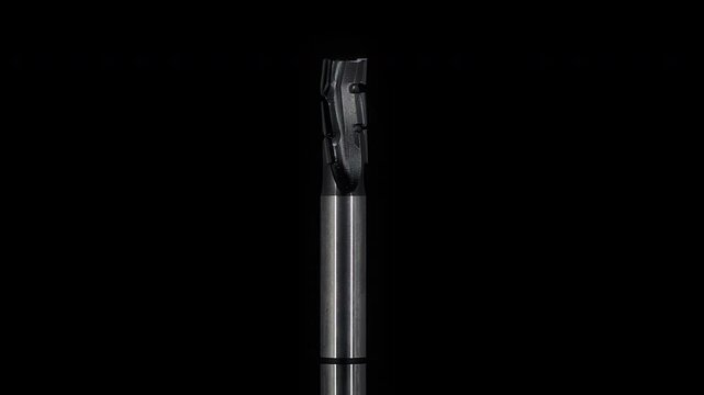 Metal end mill on black background in rotary motion