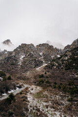 Majestic mountain landscape of Kyrgyzstan shrouded in mist reveals nature's untouched beauty along a winding path