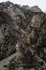 Stunning landscape of rocky mountains in Kyrgyzstan with a winding path through the rugged terrain