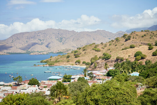 Coastal village in Komodo Islands with boats and mountains

