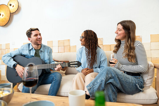 Friends enjoying a home party with wine and live music